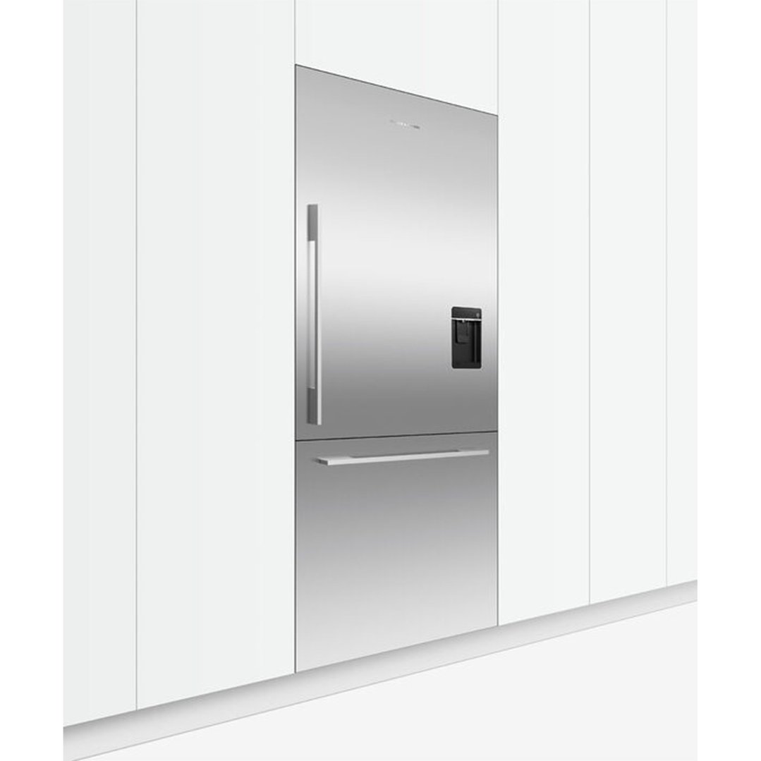 Stainless steel integrated refrigerator freezer with ice and water dispenser in a kitchen