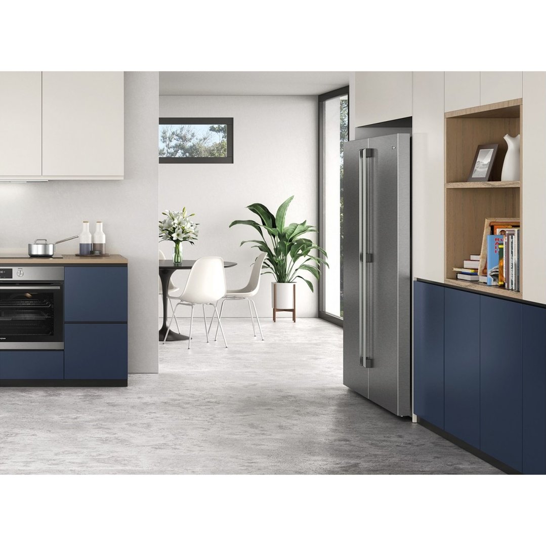 Stainless steel single door freezer in a modern kitchen with blue and white cabinets