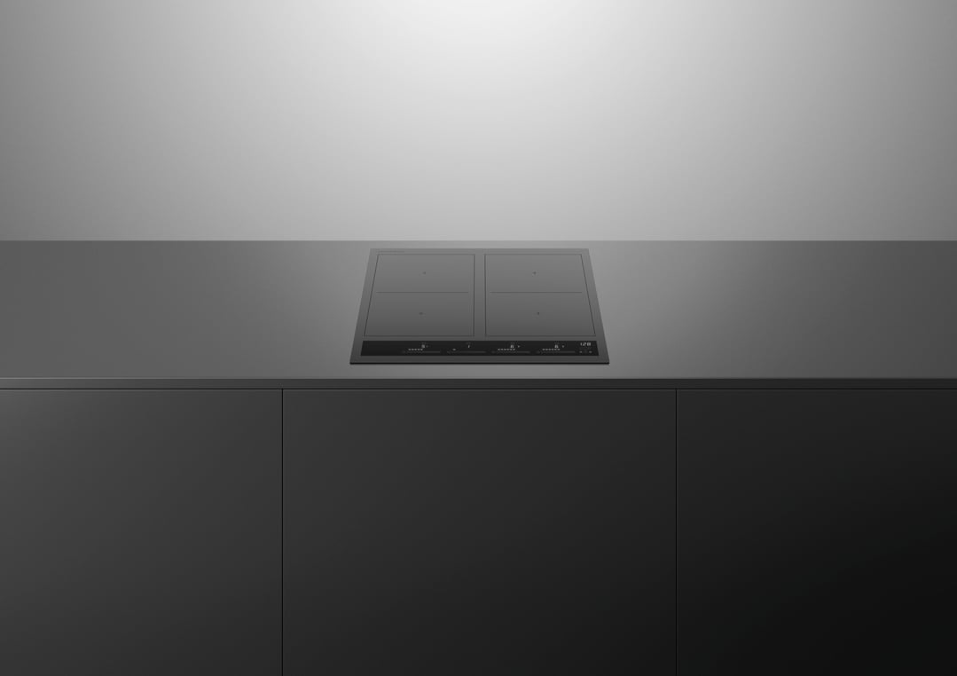 Induction cooktop built into a dark grey countertop in a modern kitchen