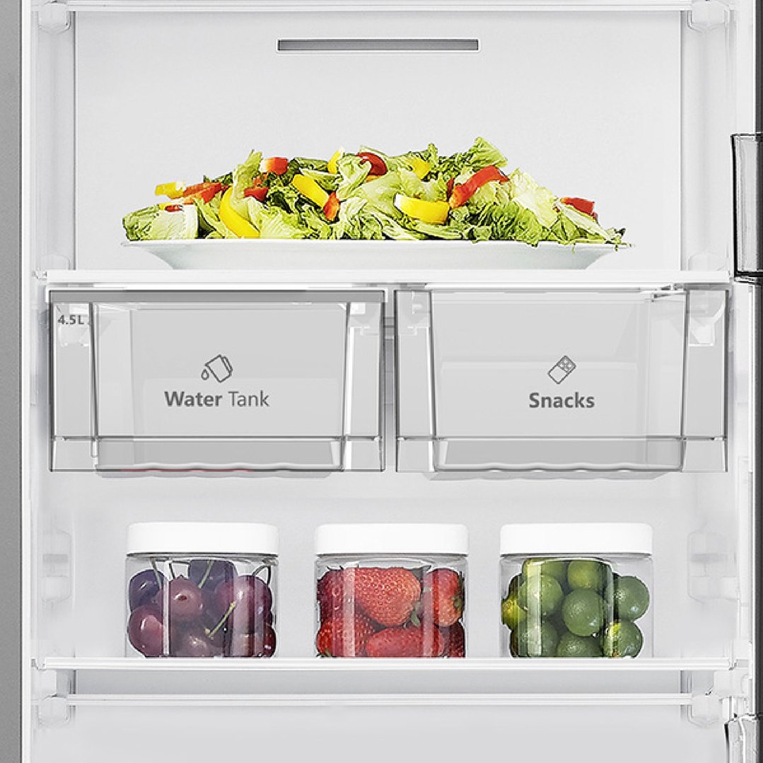 Inside a fridge with salad, water tank, snacks, cherries, strawberries, and limes