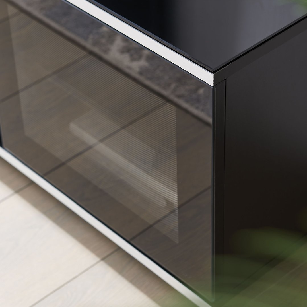 Close up of a black TV cabinet with glass door in a room