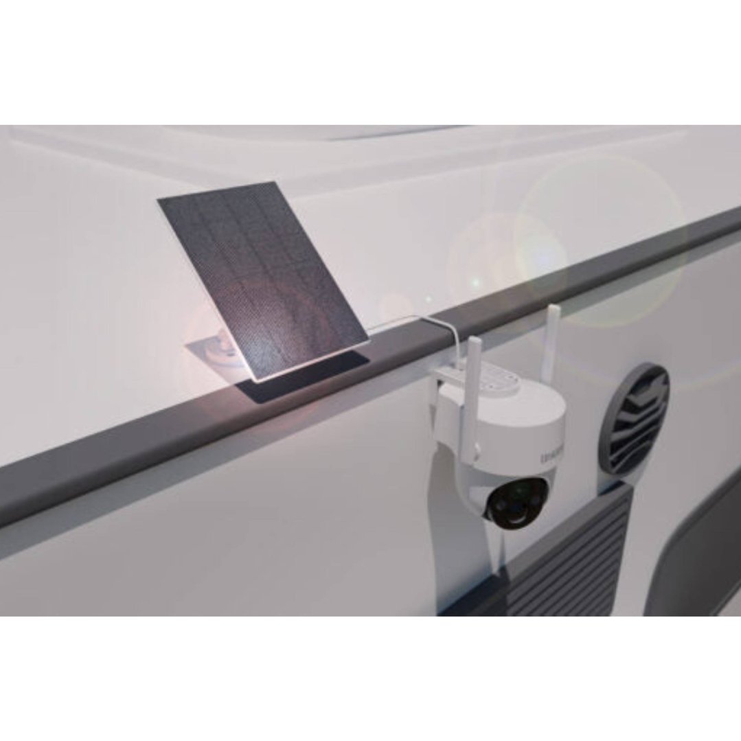 Solar panel connected to a security camera mounted on a white wall