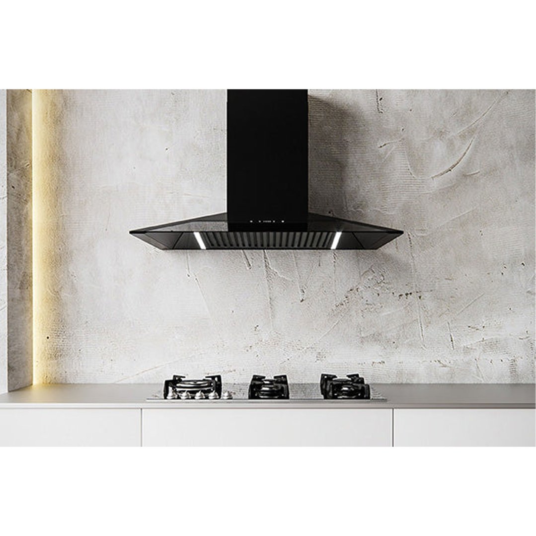 Black canopy rangehood and gas cooktop in a modern kitchen with concrete walls