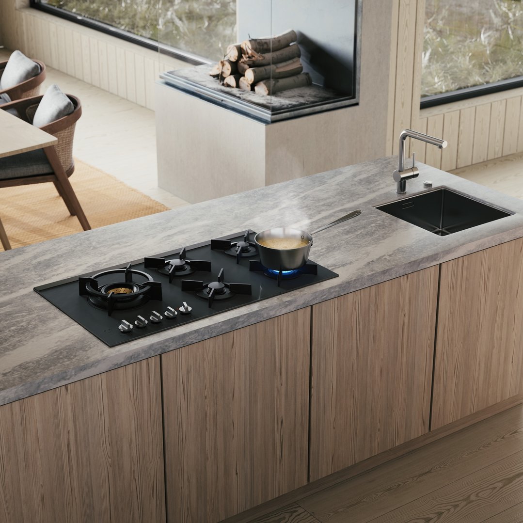A black gas cooktop with a pot boiling on a kitchen island