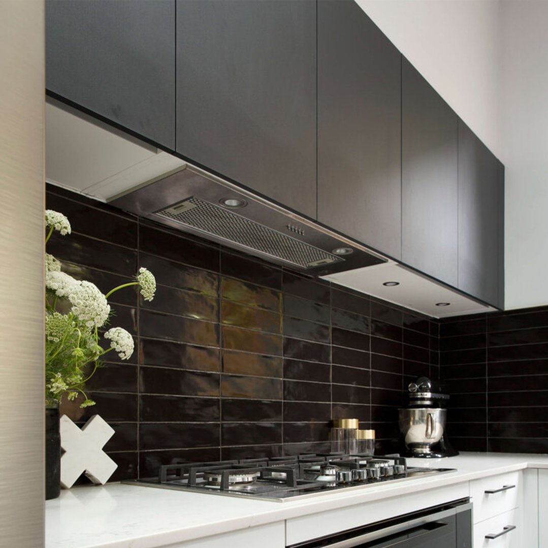 Undermount rangehood installed above a gas cooktop in a modern kitchen