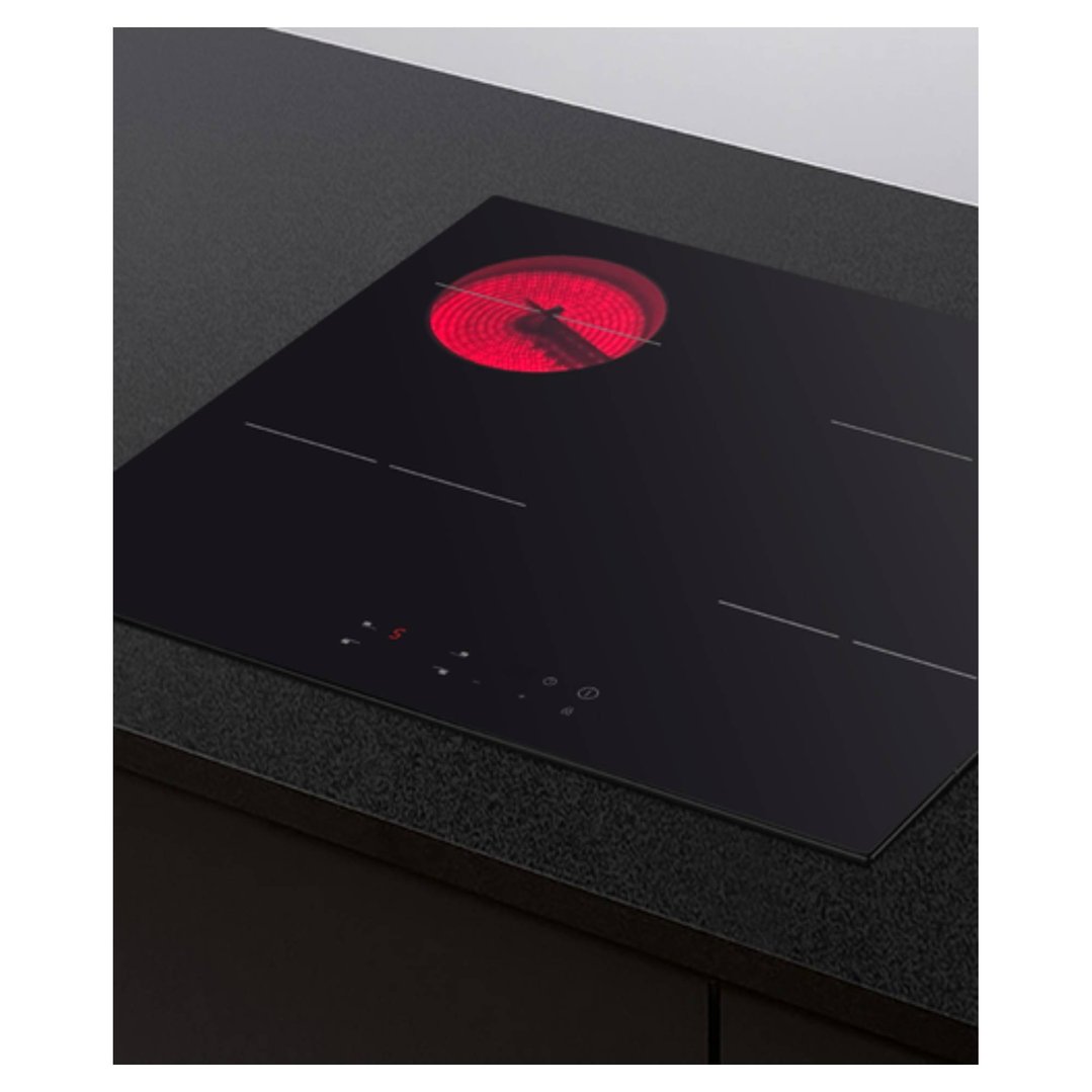 A black electric cooktop with one red hot element, built into a dark countertop
