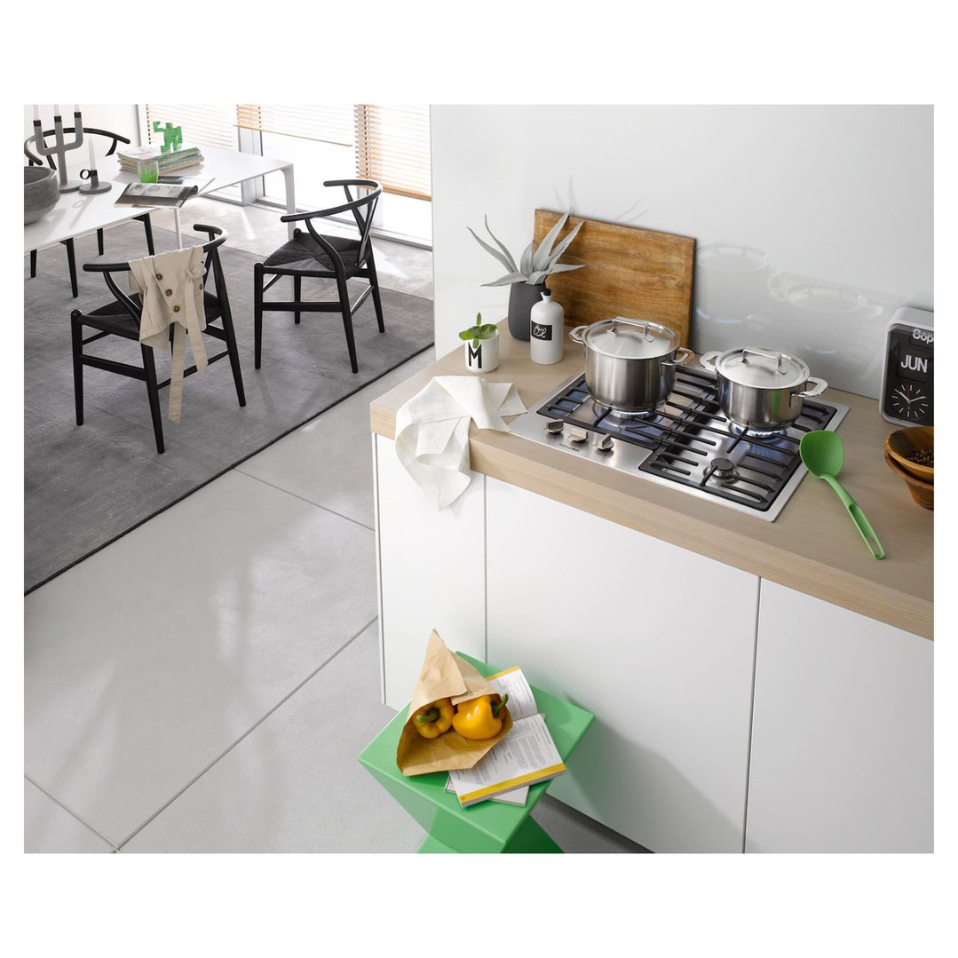A Miele 3 burner gas cooktop in a modern kitchen with pots and decor