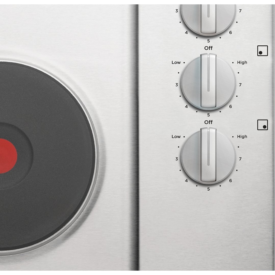 Close up of a cooktop with a solid element and control knobs