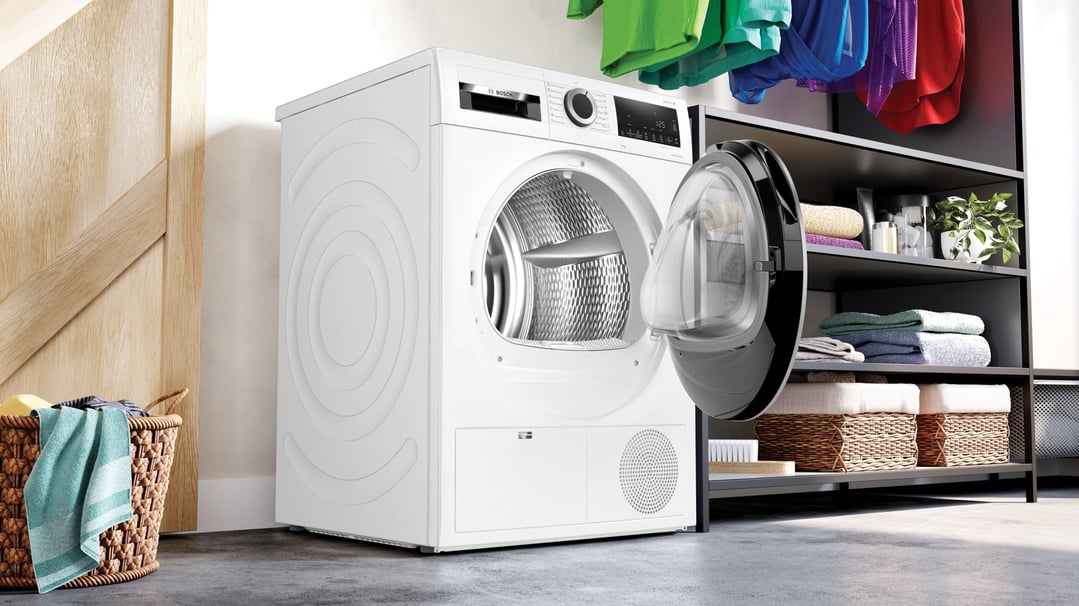 Bosch 9kg Series 6 Heat Pump Dryer with door open in a laundry room