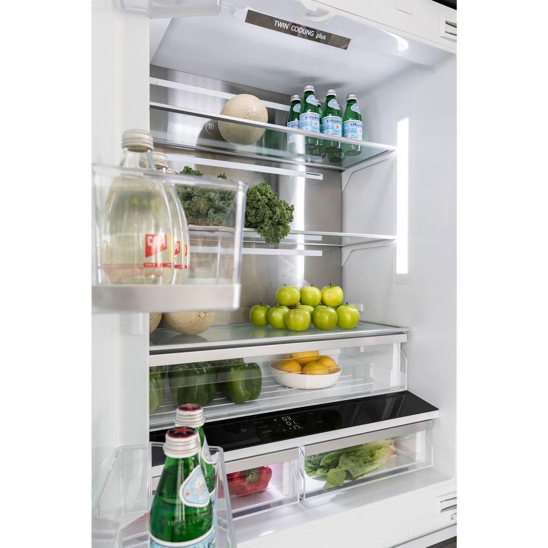Open French door fridge interior filled with fresh produce and drinks