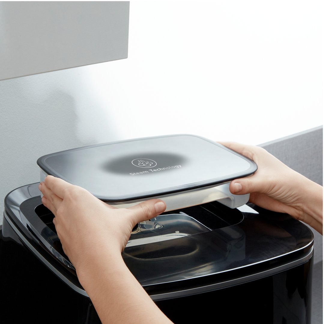 Hands placing the steam technology lid onto the Easy Fry Grill & Steam XXL Air Fryer