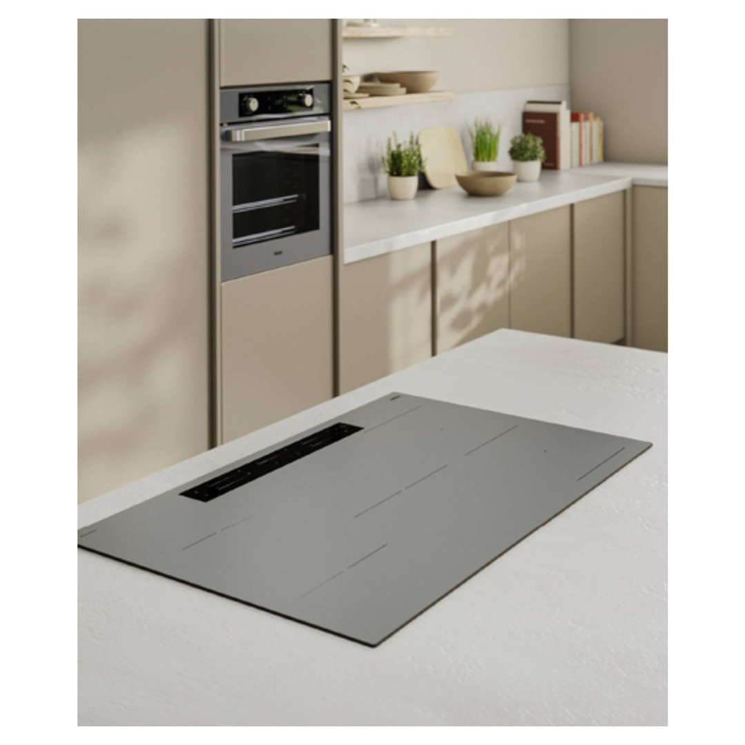Grey glass induction cooktop on a white kitchen island in a modern kitchen