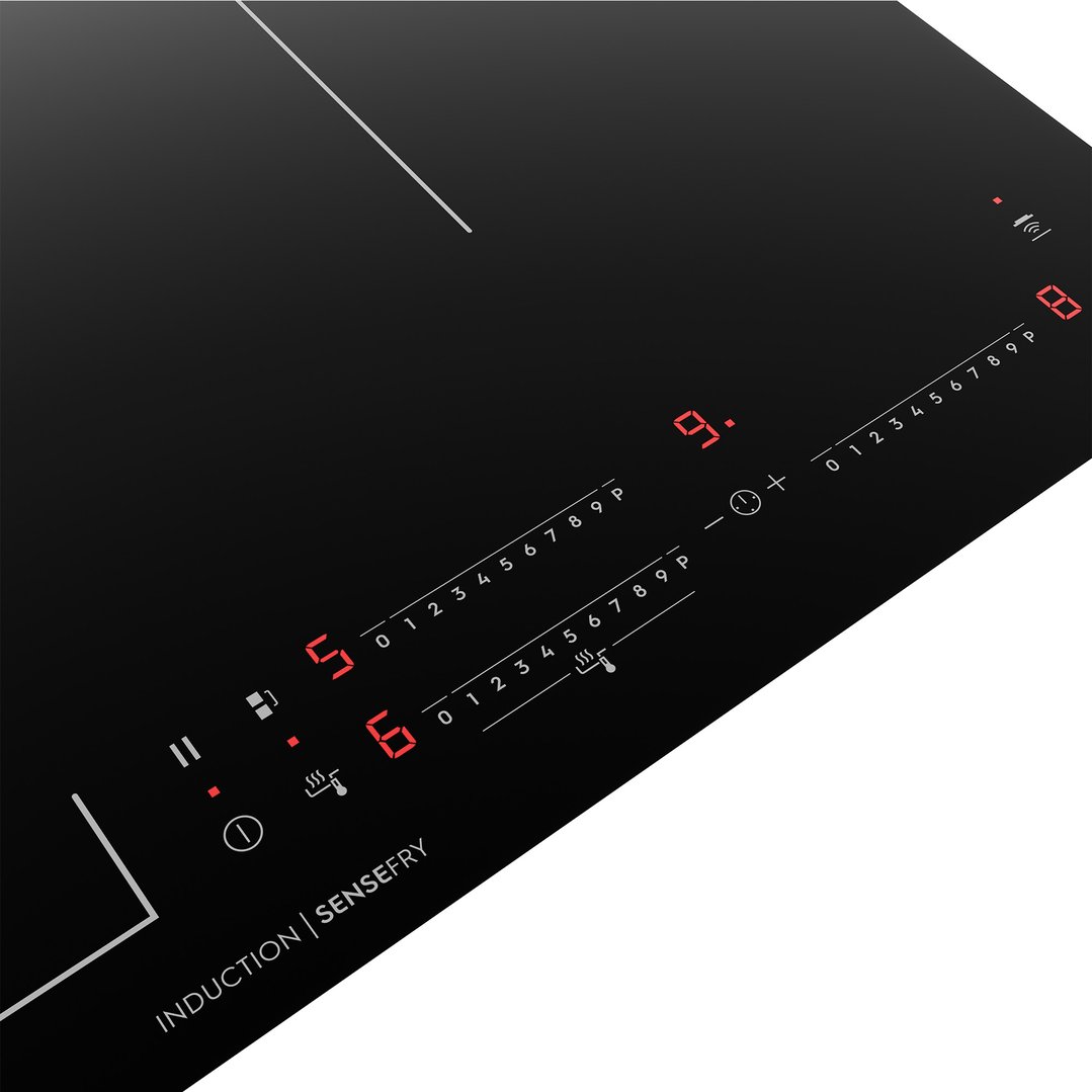 Close up of an induction cooktop with digital controls and red displays