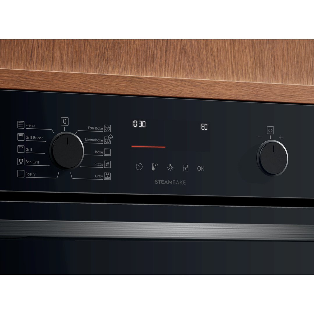 Close-up of an oven's control panel with a digital display and rotary knobs