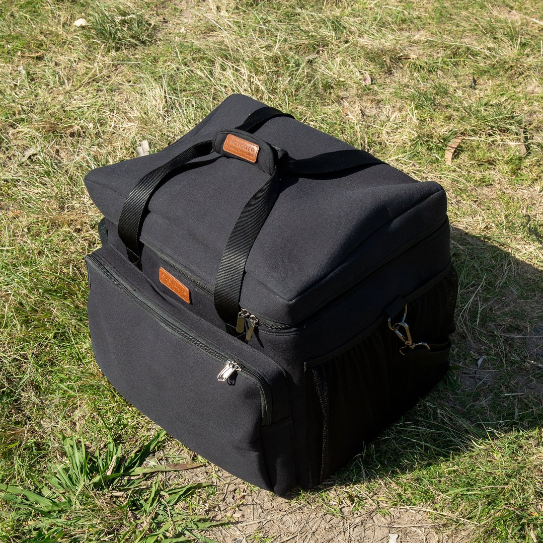 Black carrier bag with brown leather tag on green grass