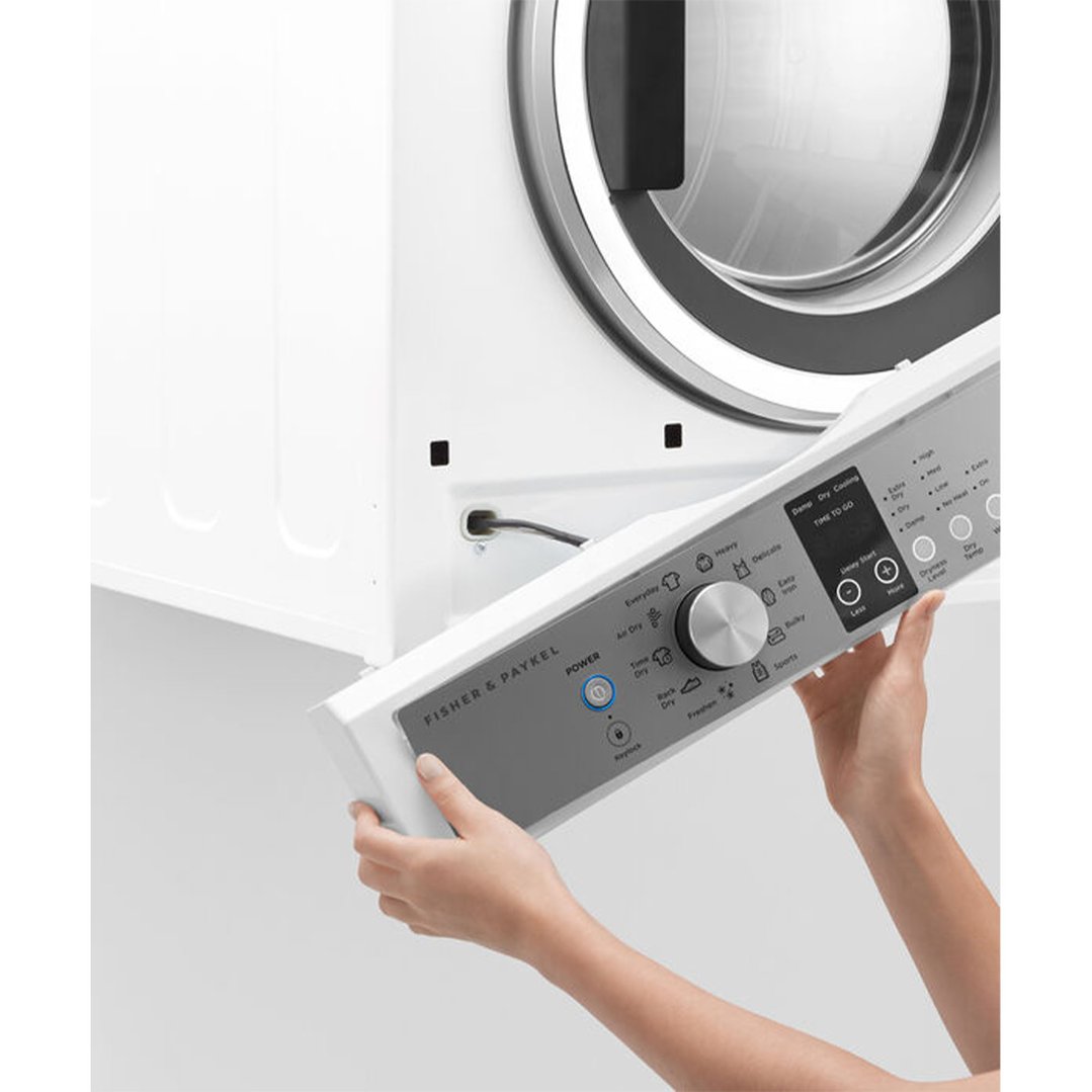 Hands adjusting the control panel of a white Fisher & Paykel dryer