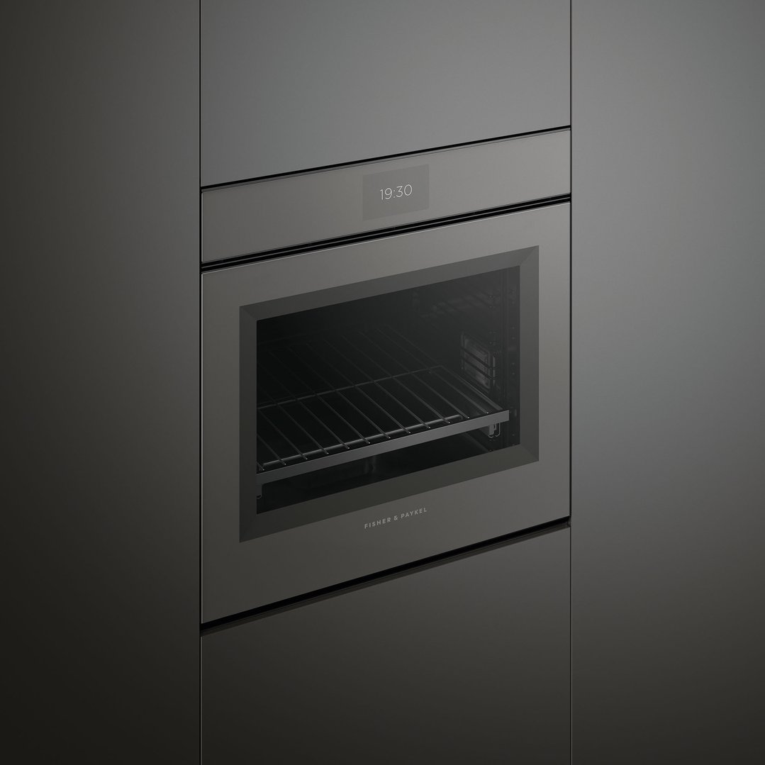 Black built-in oven with a digital display showing 19:30 in a dark kitchen
