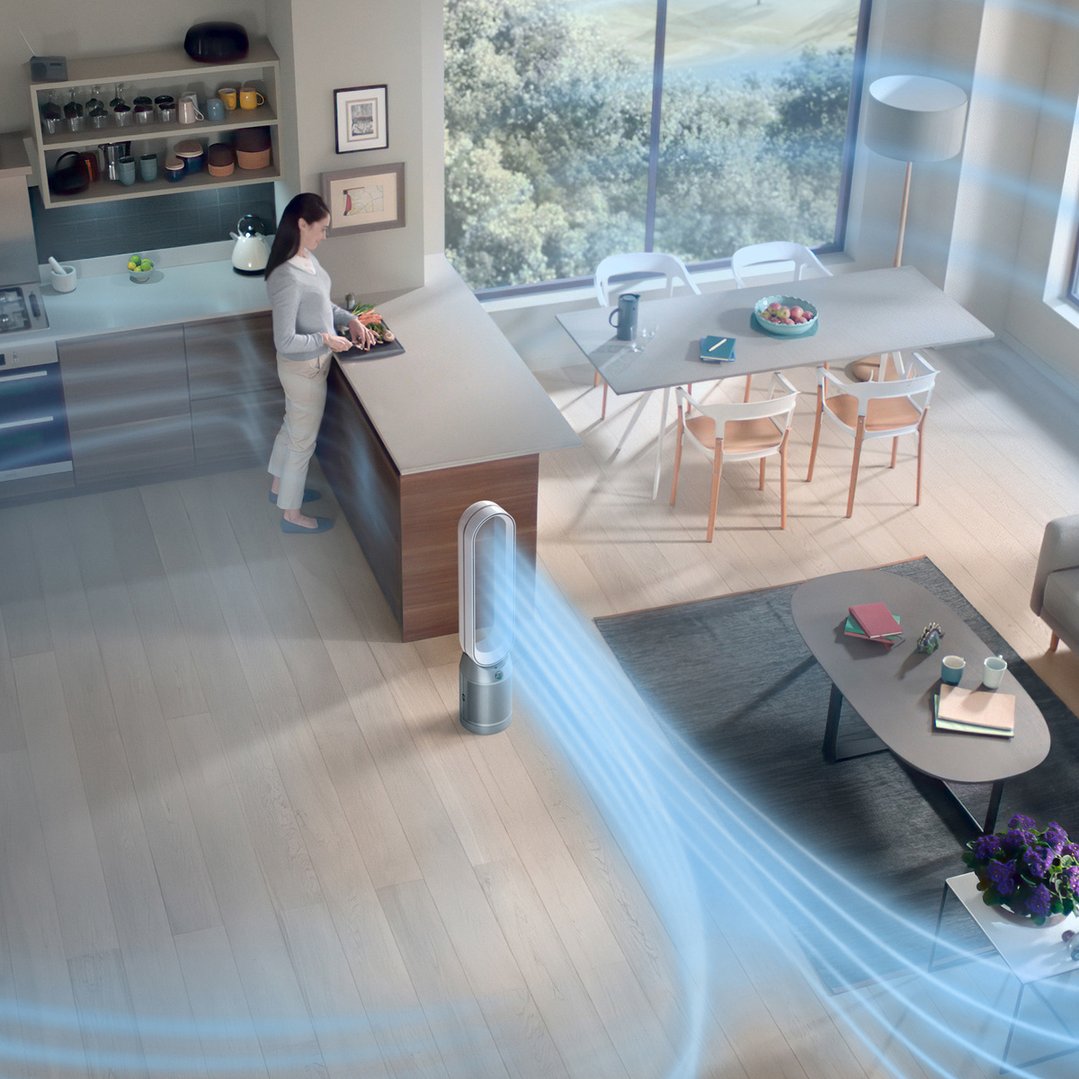 Woman preparing food in kitchen with a Dyson air purifier in foreground