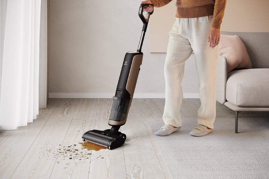 Person cleaning a dirty floor with an Electrolux UltimateHome 700 Wet & Dry Vacuum