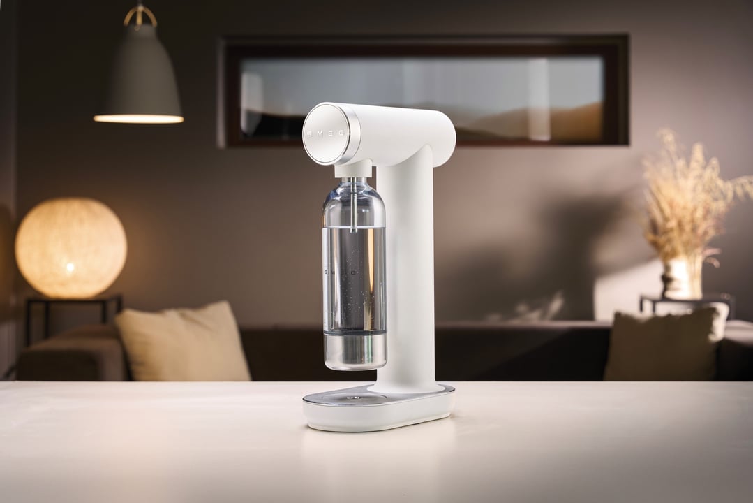 SMEG soda maker on a white table in a living room setting
