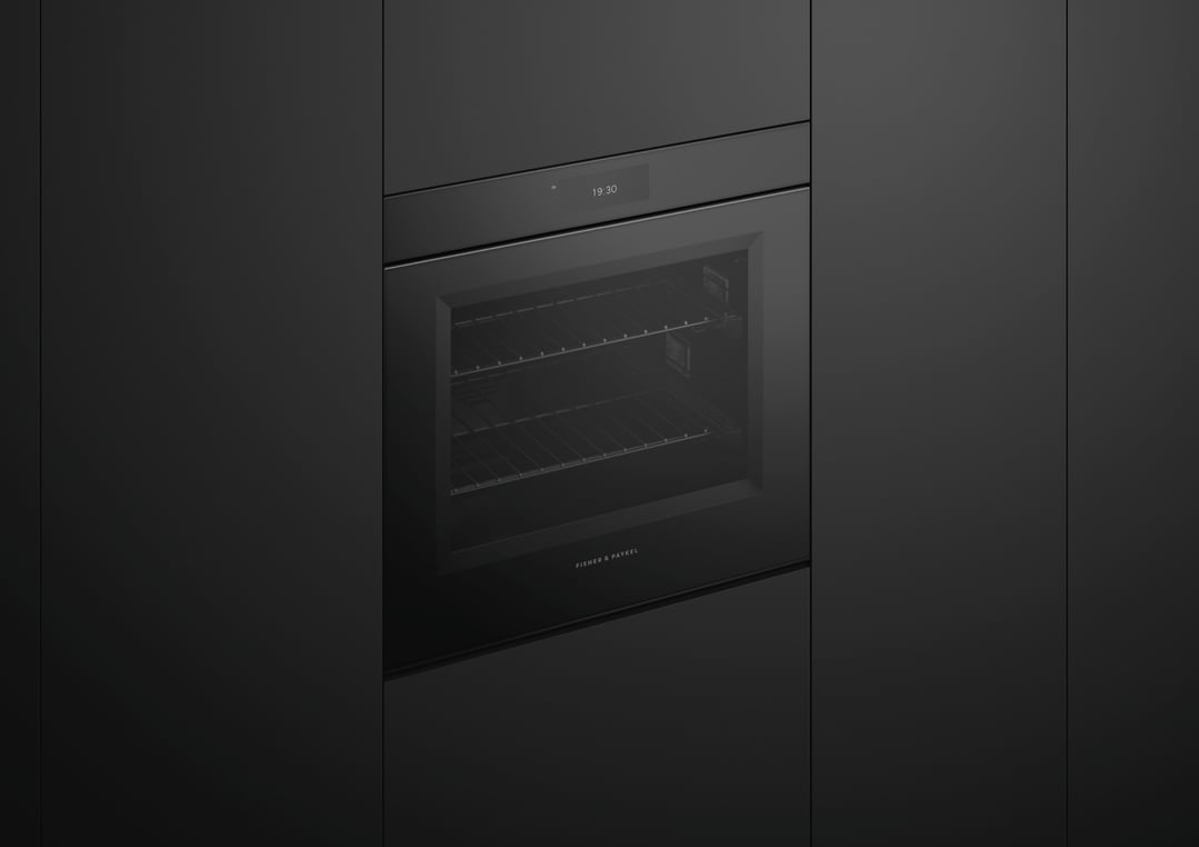 Black glass oven built into dark cabinetry with digital display showing 19:30