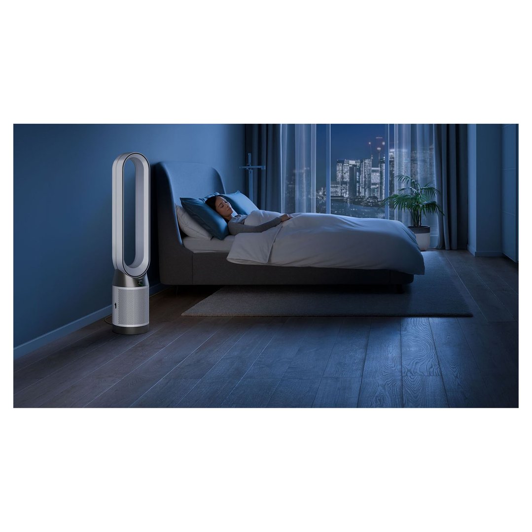 Dyson air purifier in a bedroom with a person sleeping at night