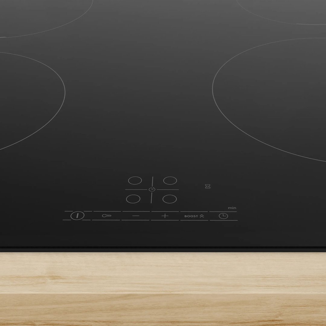 Black induction cooktop with controls on a light wood countertop