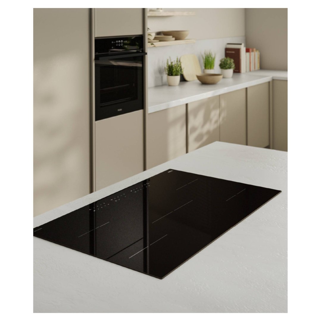 Black induction cooktop on a white countertop in a modern kitchen