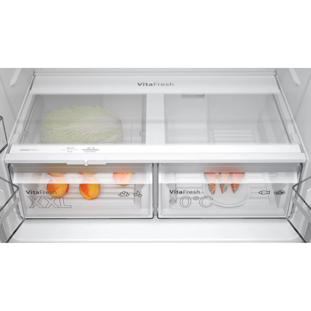 Inside view of a Bosch fridge showing VitaFresh drawers with fruit, vegetables, and fish