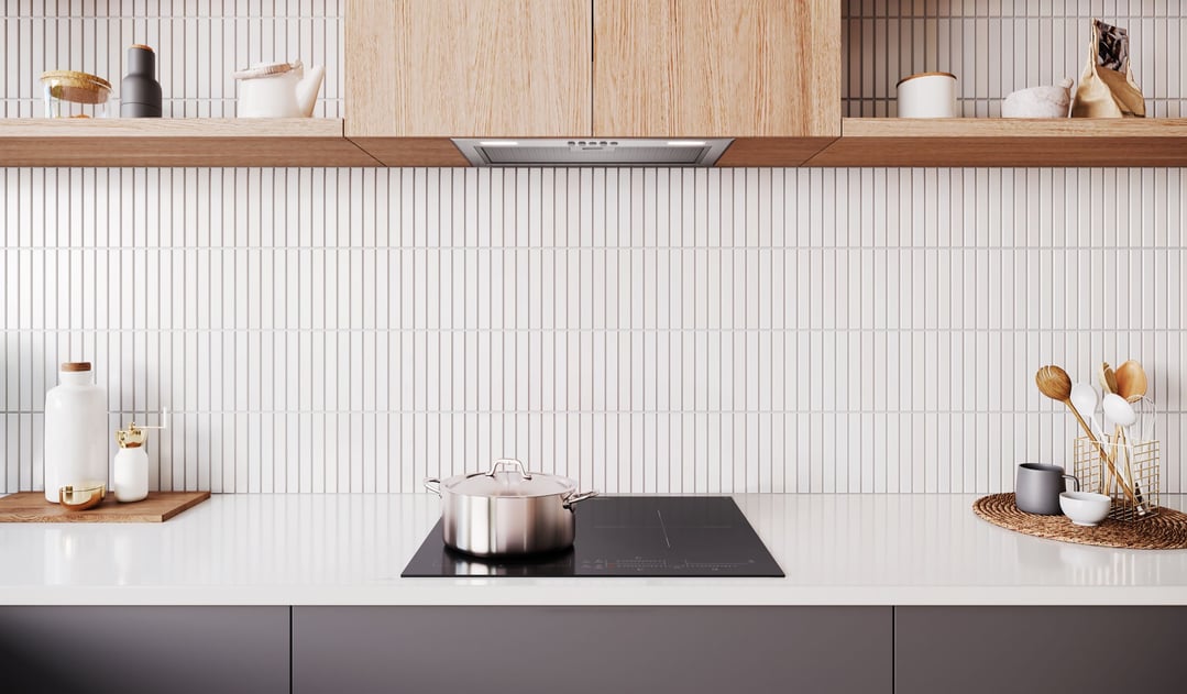 Stainless steel pot on a black induction cooktop in a modern kitchen