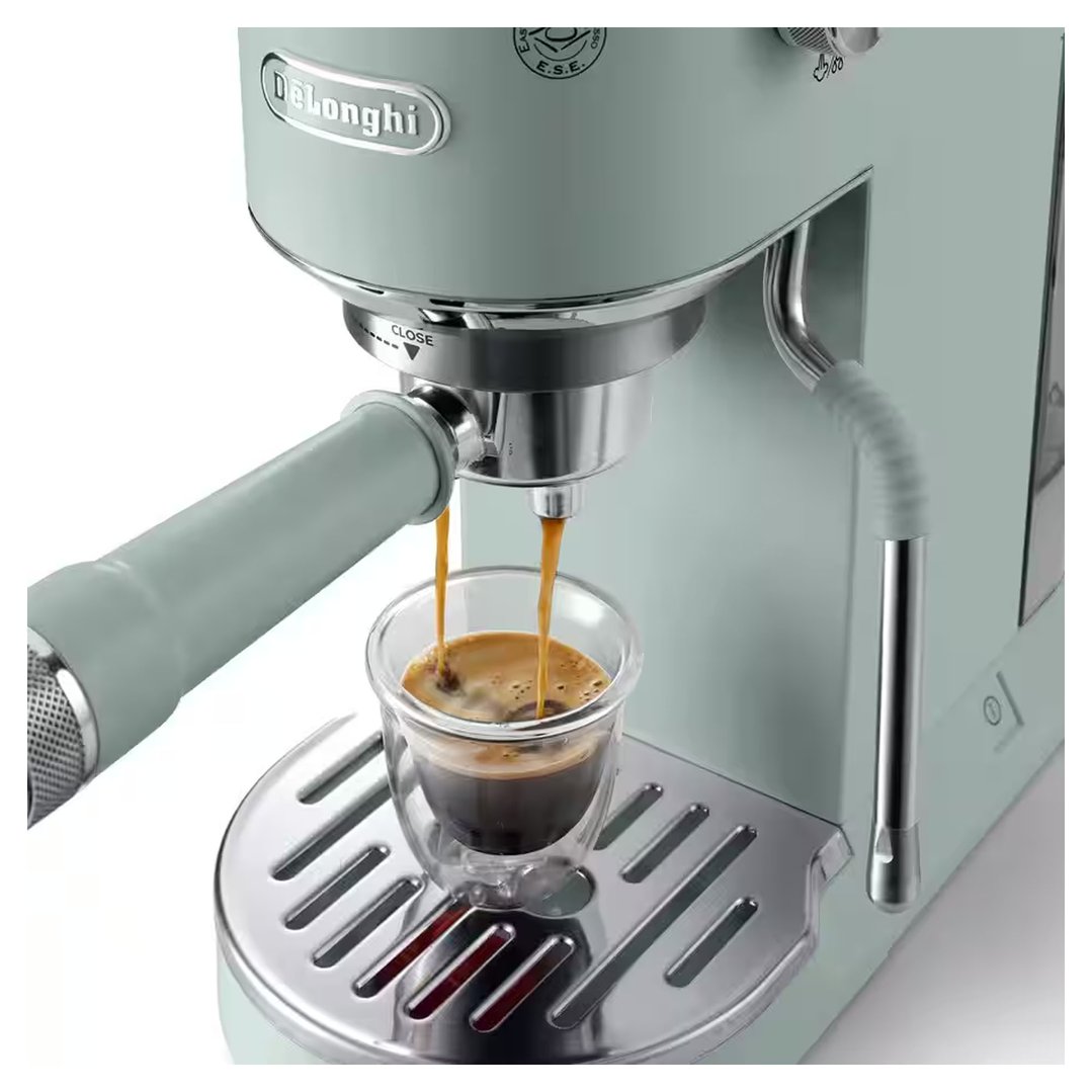 Green DeLonghi coffee machine dispensing espresso into a glass cup