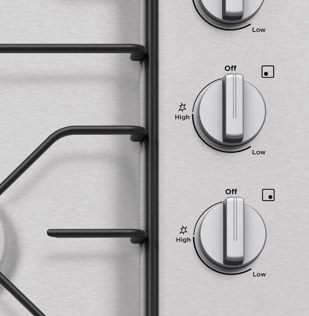 Close up of cooktop controls and grates on a stainless steel surface