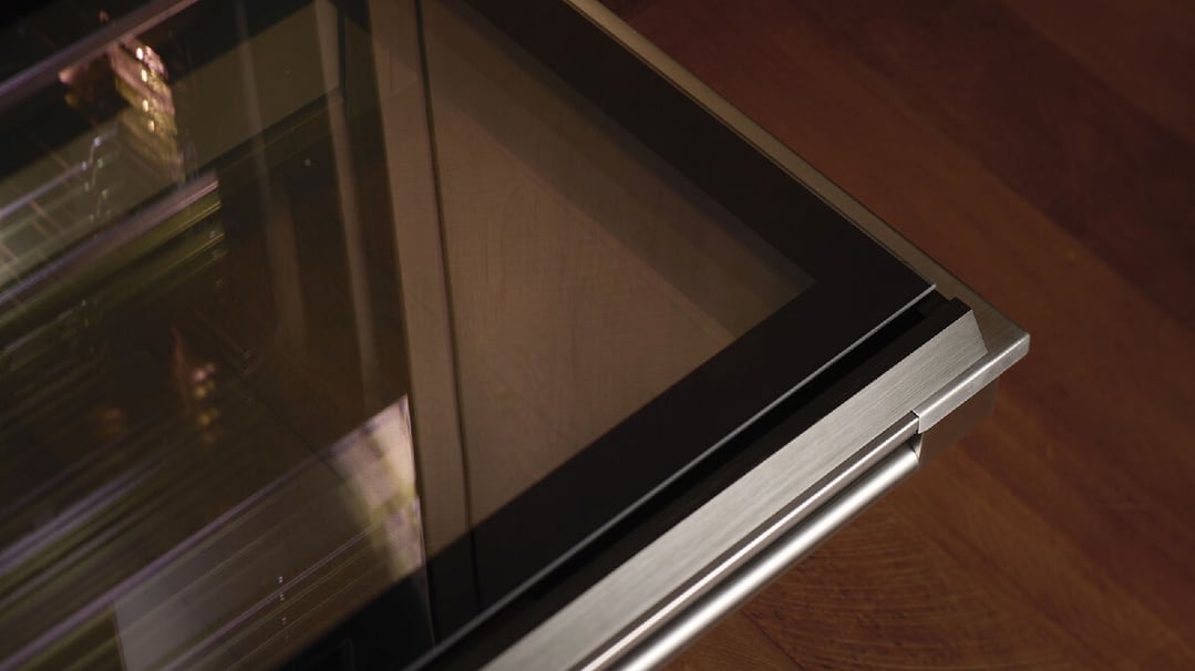 Close-up of a built-in oven with a glass door and stainless steel handle