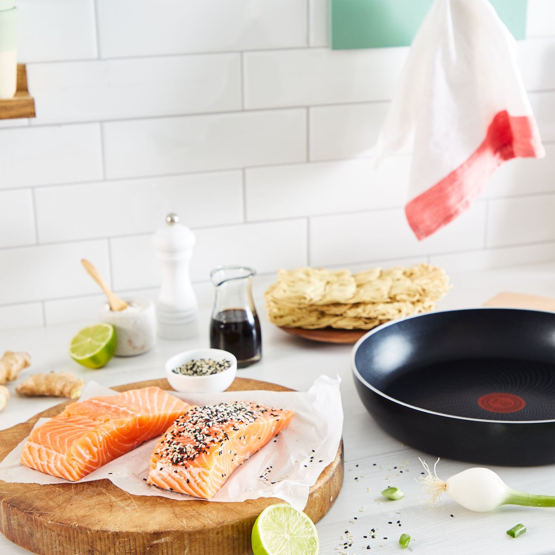 A Tefal Generous Cook Induction Non-Stick Frypan on a kitchen counter with ingredients