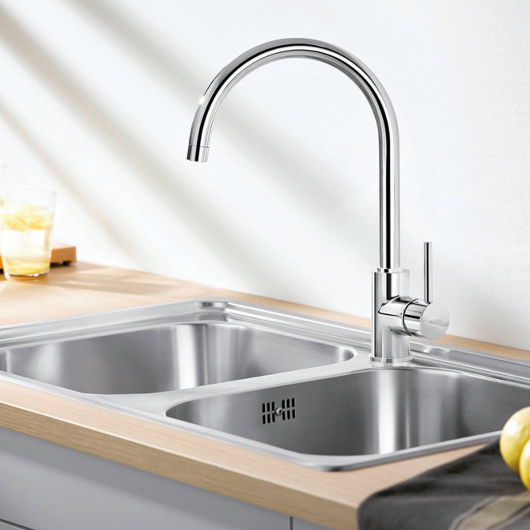 Chrome single lever high arch tap installed in a double stainless steel sink