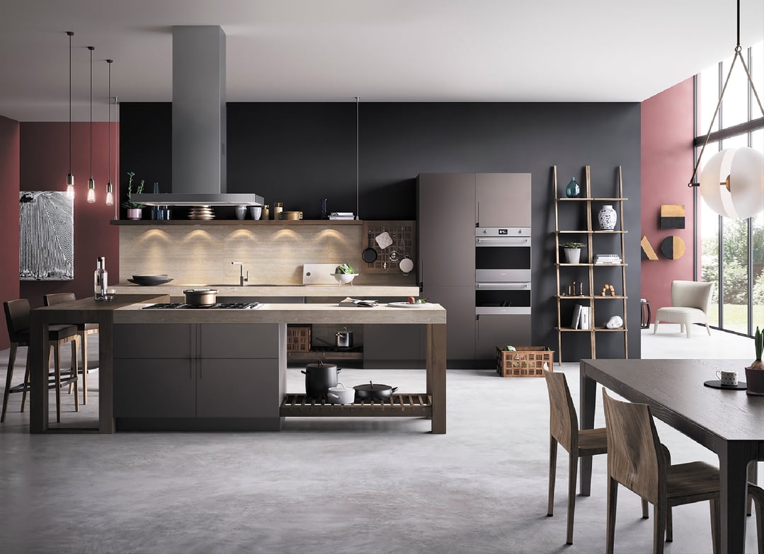 Double oven built into dark cabinetry in a modern kitchen with island and dining area