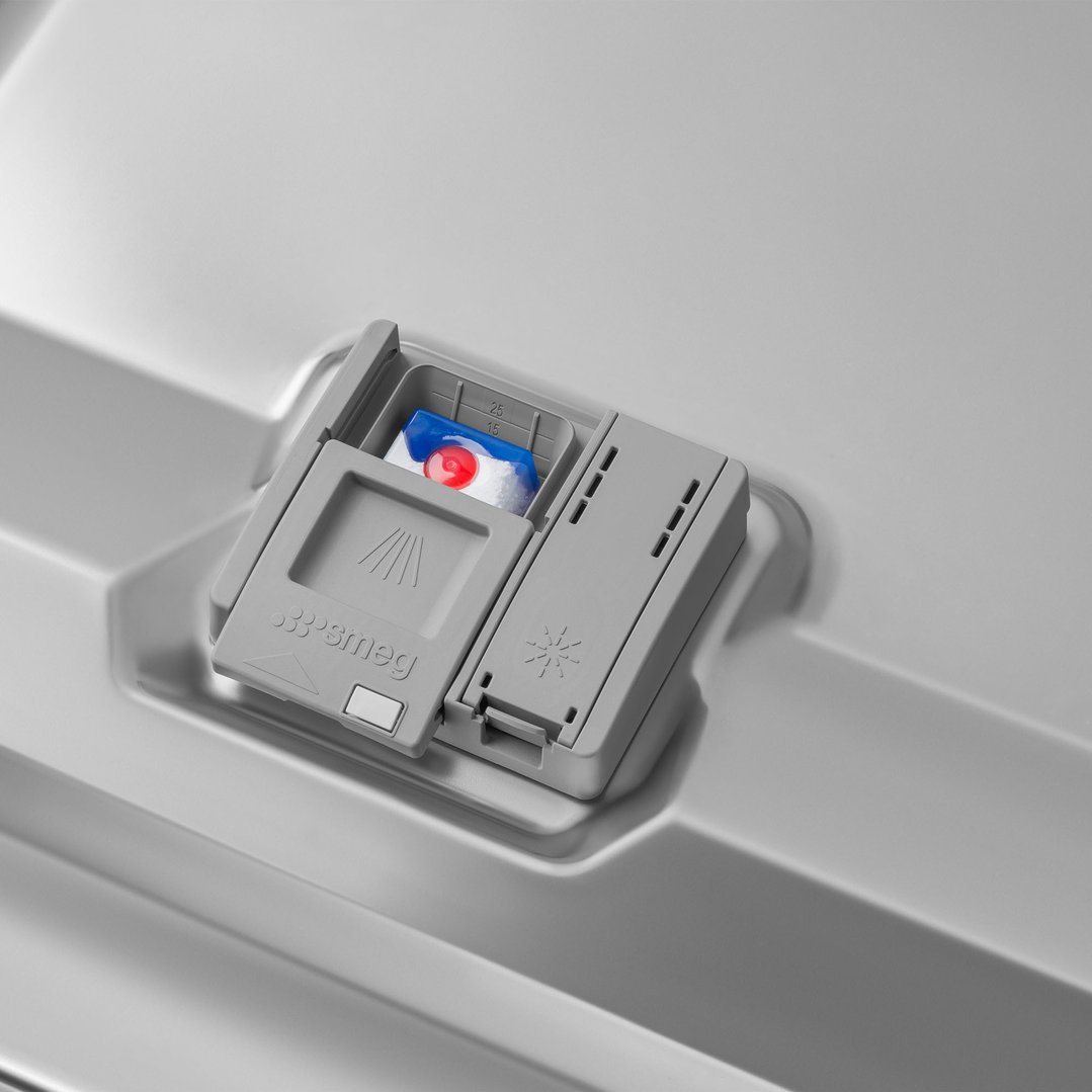 Close up of a dishwasher detergent dispenser with a tablet inside