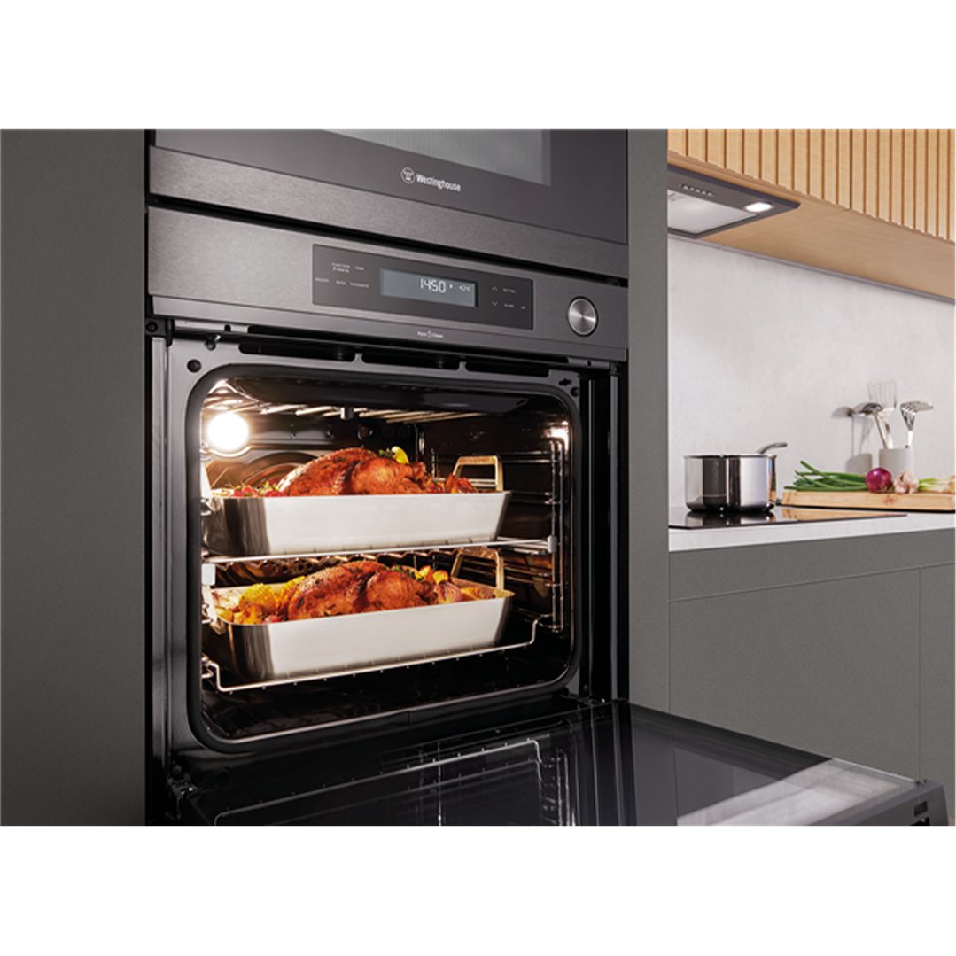 Two roasted chickens in an open oven in a modern kitchen