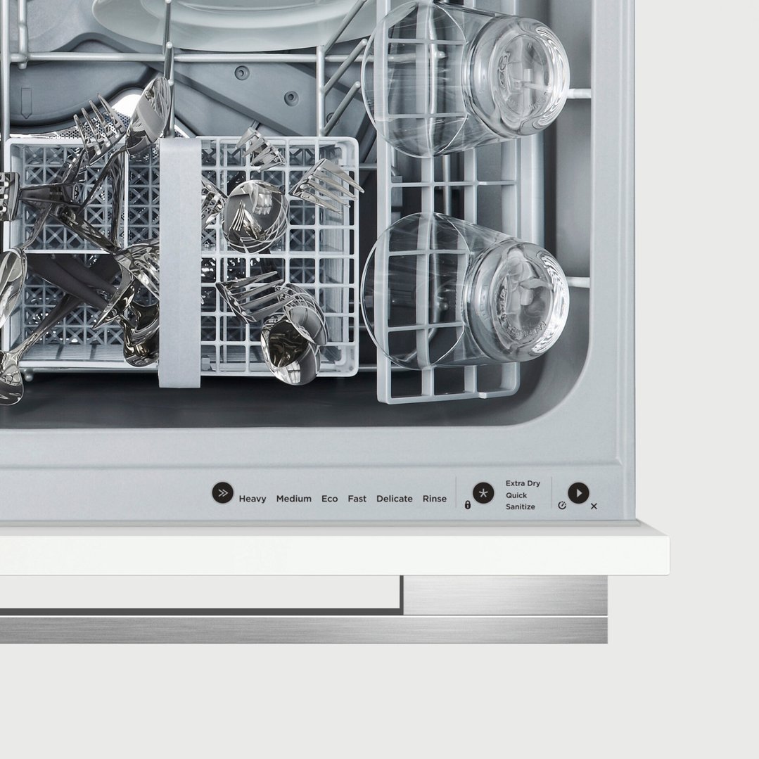 Close up of the interior of a dishwasher with dishes and controls