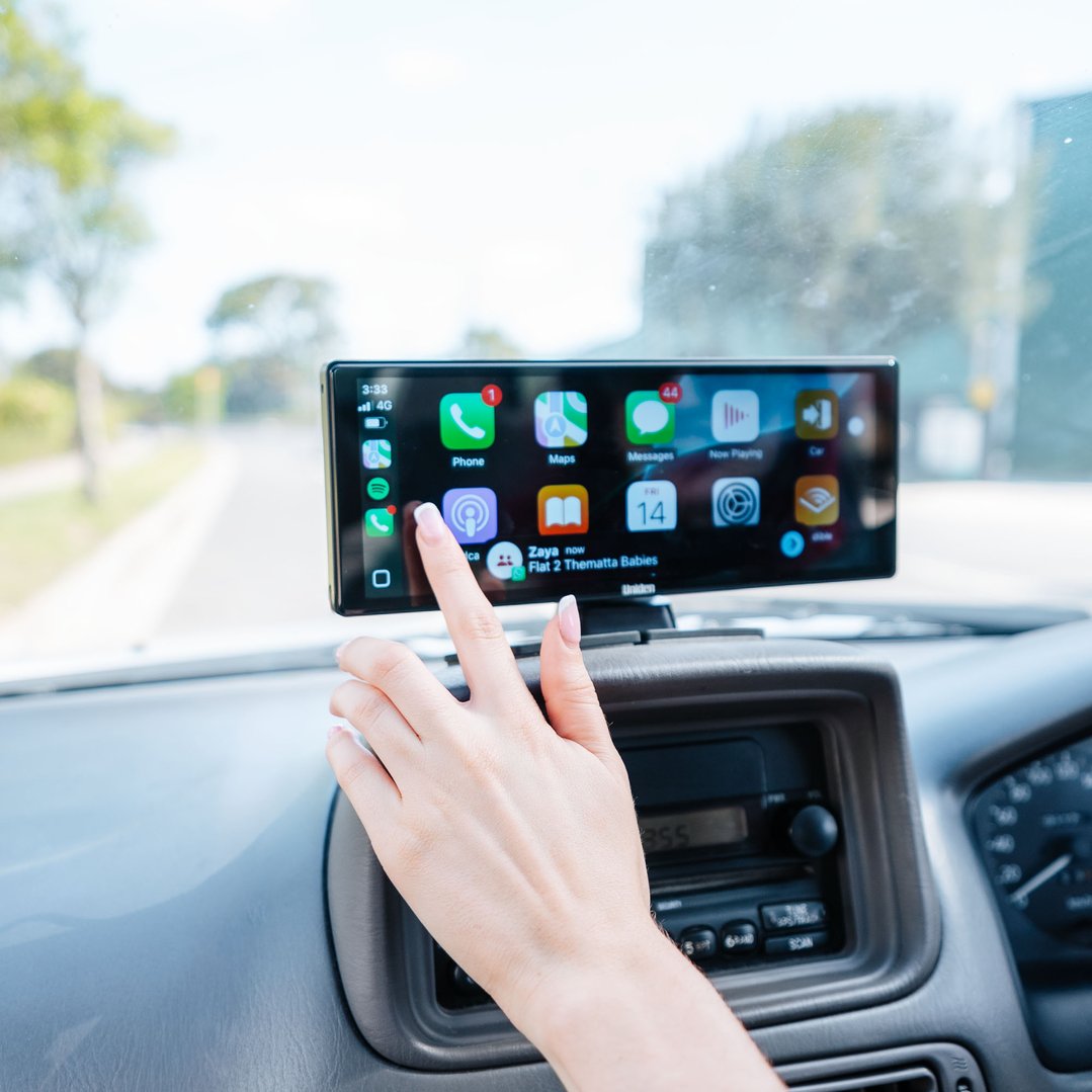 Hand interacting with a Uniden 10.26" wireless carplay screen in a car