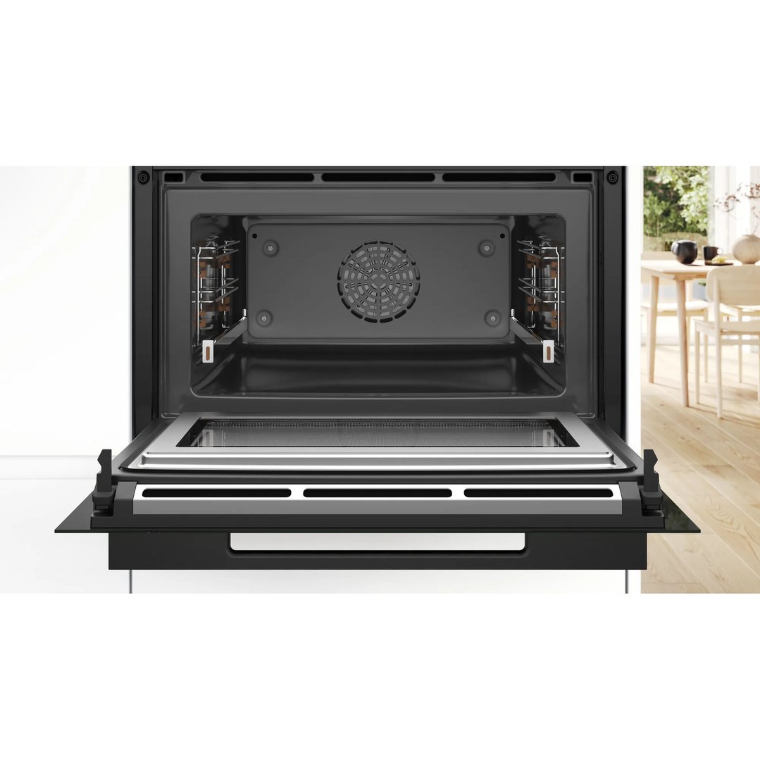 Open built-in combination oven with microwave in a modern kitchen setting