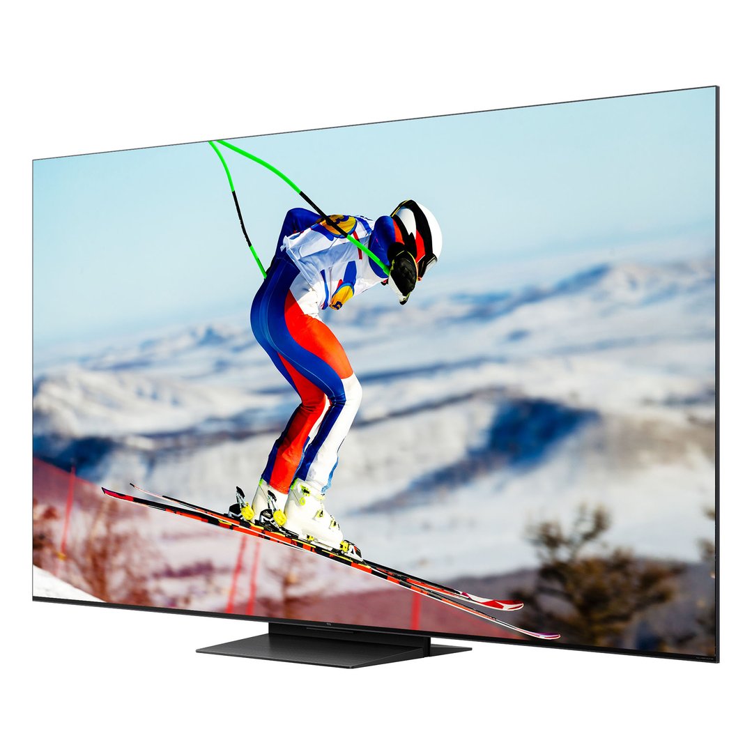 TCL TV on a stand displaying a skier on a snowy mountain