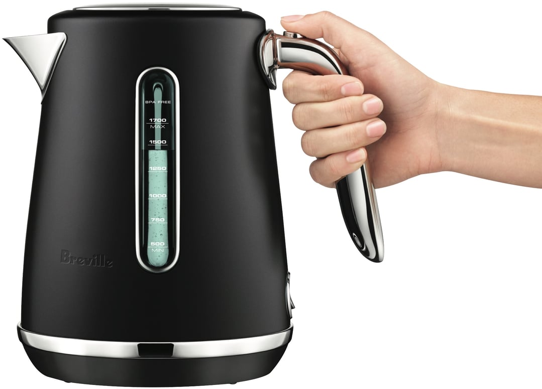 Hand holding a black Breville kettle with a water level indicator