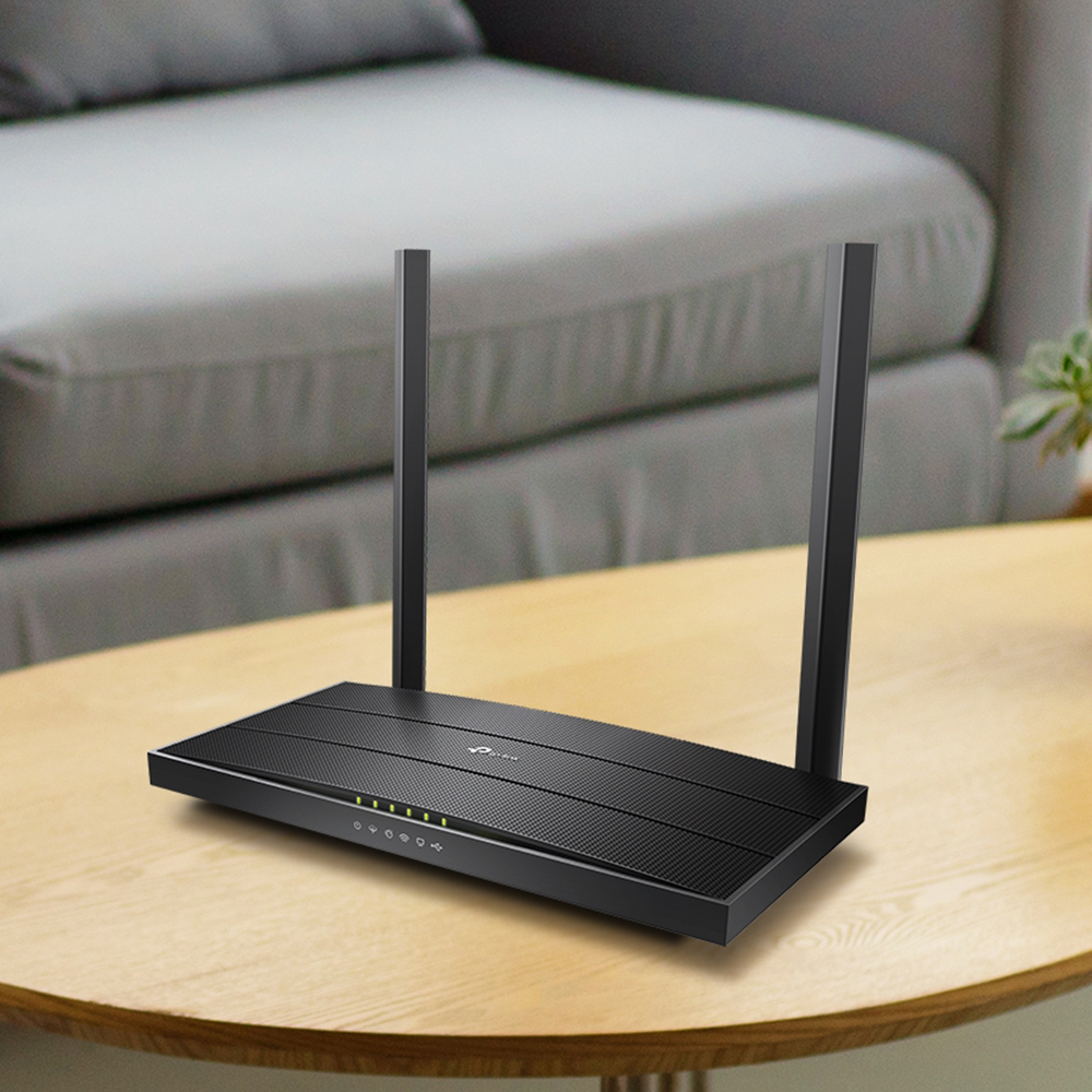 Black TP-LINK modem router with two antennas on a wooden table
