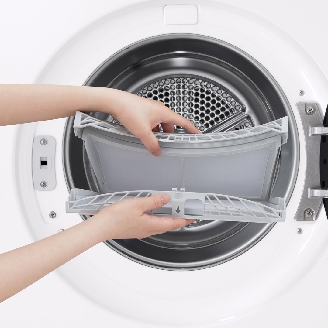 Hands removing the lint filter from the drum of a white LG dryer
