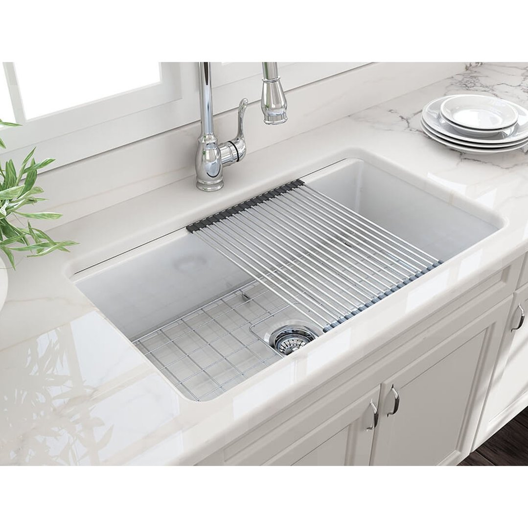 Roll-up sink drainer in a white kitchen sink with a chrome faucet