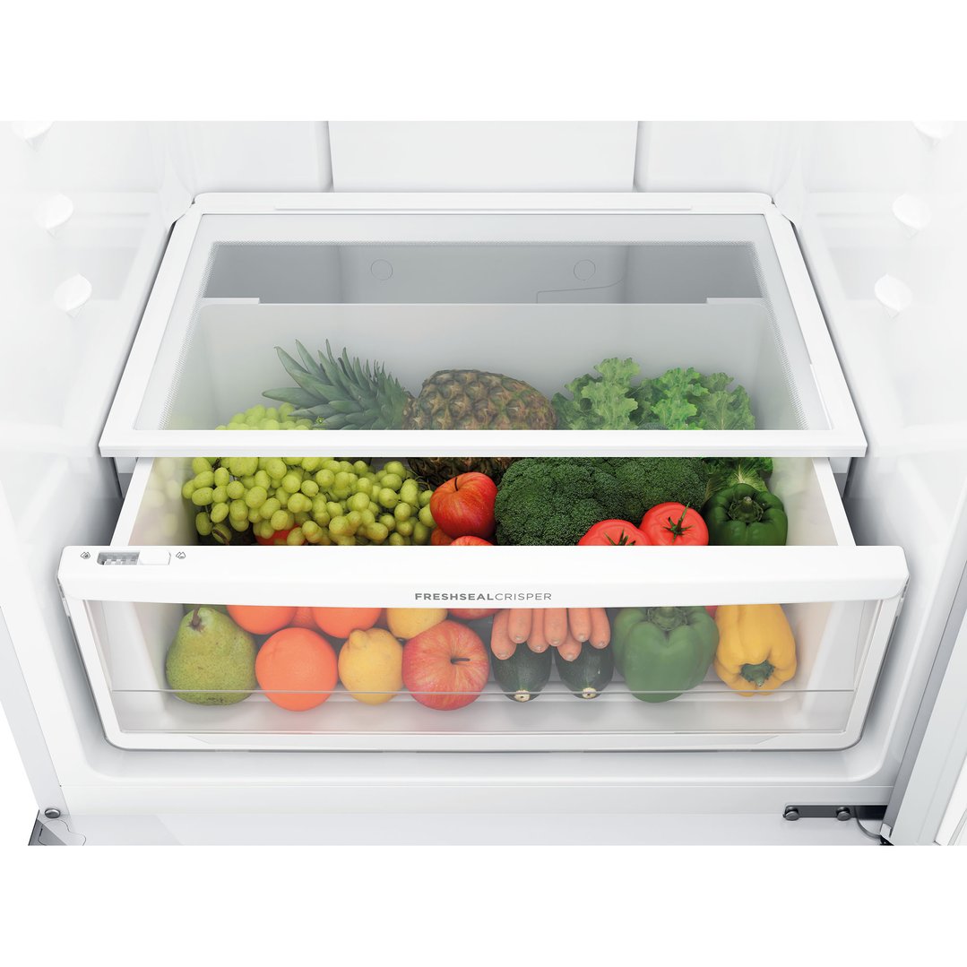 Crisper drawers filled with fresh fruits and vegetables inside a fridge