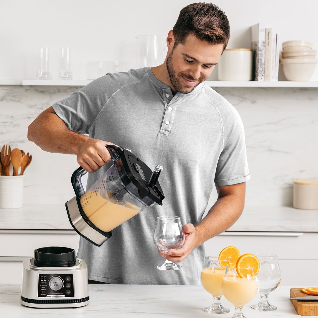Man pouring a blended drink from a Ninja Foodi Power Blender & Processor System