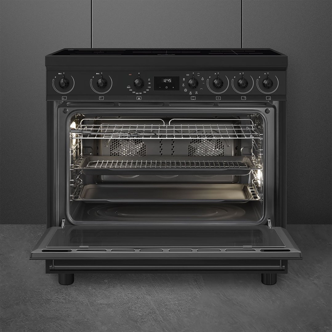 Matte black freestanding oven with door open, showing interior racks and trays