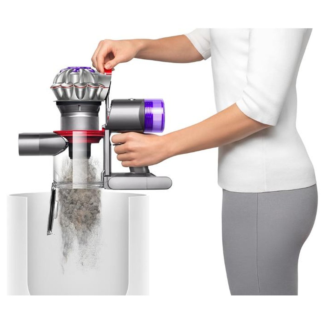 Person emptying the dustbin of a Dyson handstick vacuum cleaner
